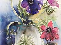 Purple, red and yellow anemones twisting out of their vase