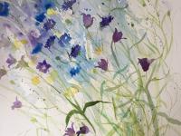 Blue cornflowers and companula flowers blowing over to the left with butterfly