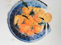 Bright satsumas in a collaged dish.