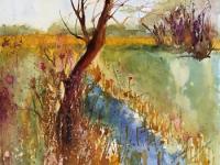 Brown leaning tree over blue water with fields beyond