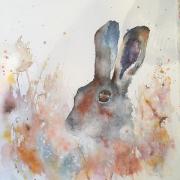 Brown hare peeping out of autumn foliage