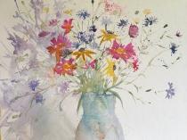 Wild flowers in a mass of colour in a pale blue jug
